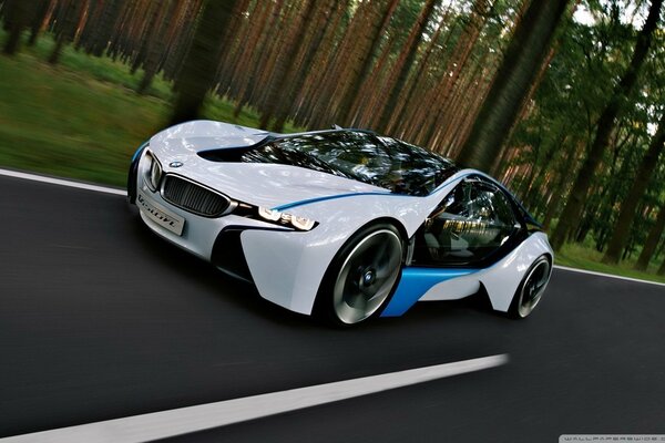 A white electric car rides on perfect asphalt