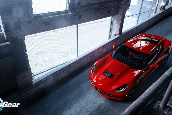 Chevrolet rojo monta en un edificio sombrío