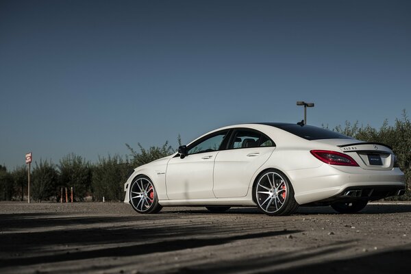 White Mercedes on the side of the parking lot