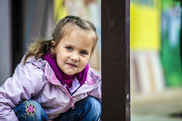 La niña se sienta y se avergüenza cuando la fotografían