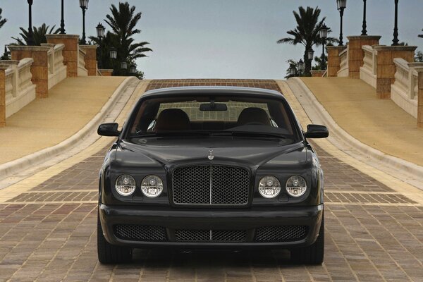 Bentley negro en la carretera de adoquines, vista frontal