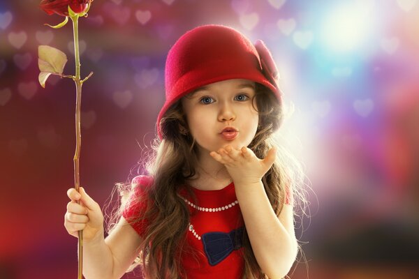 A child in red clothes and with a rose in his hands