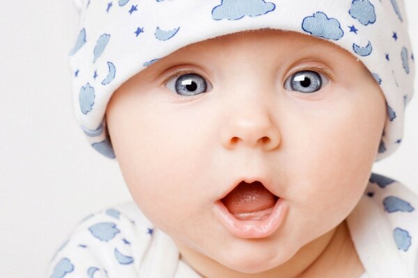 A child with blue eyes in a white cap