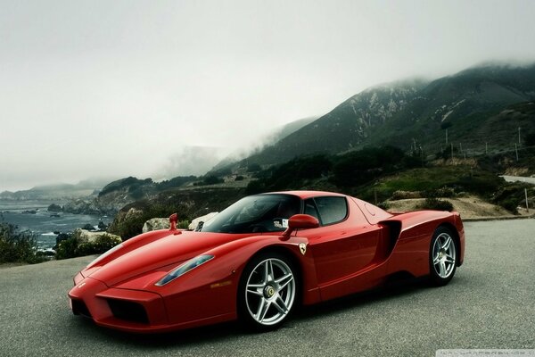 Roter Ferarri auf dem Hintergrund der Felsen