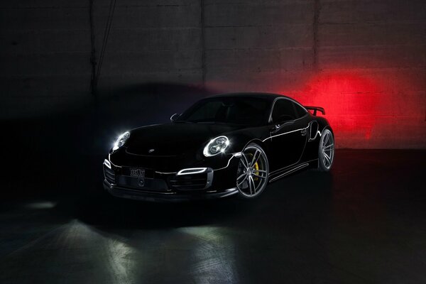Porsche 911 negro con faros encendidos