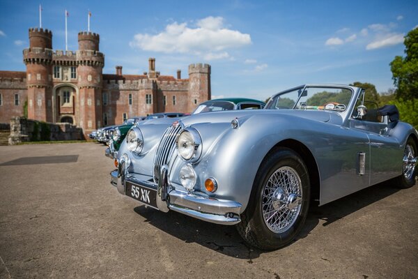 A retro car stands near a castle in England