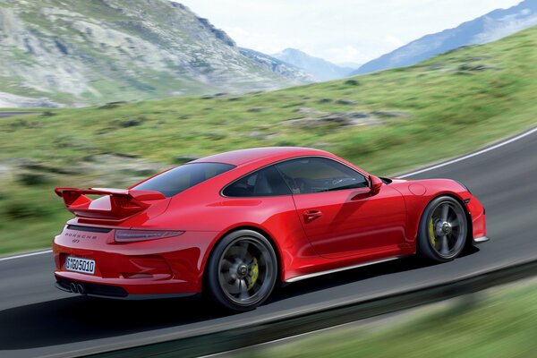 Una Porsche 911 gt3 rossa che guida su strada