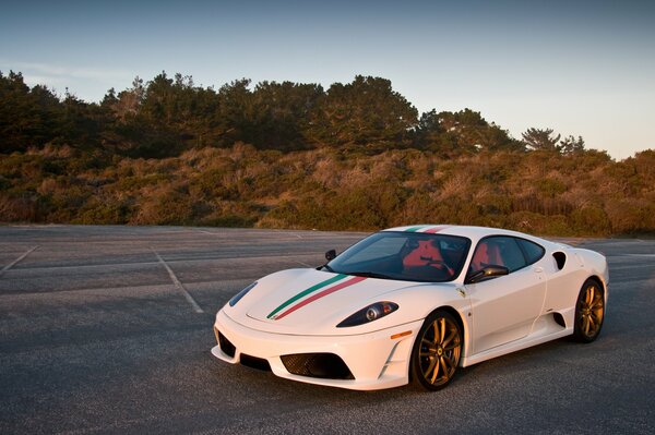 Białe ferrari f430 scuderia w godzinach wieczornych