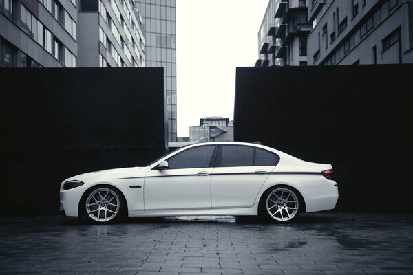 Auto BMW di colore bianco su uno sfondo di edifici