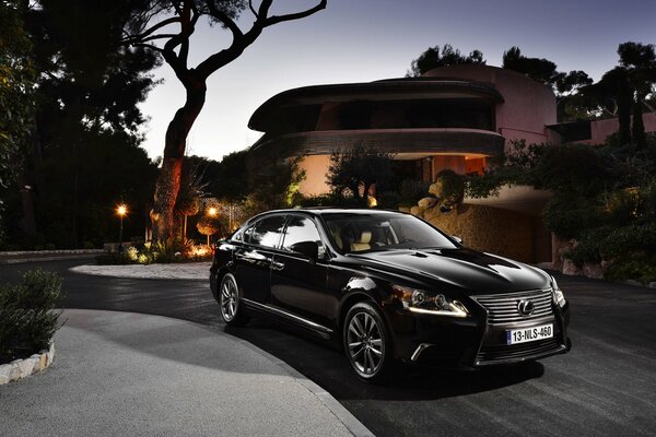 Schwarze Lexus LS Limousine am Abend neben dem Haus
