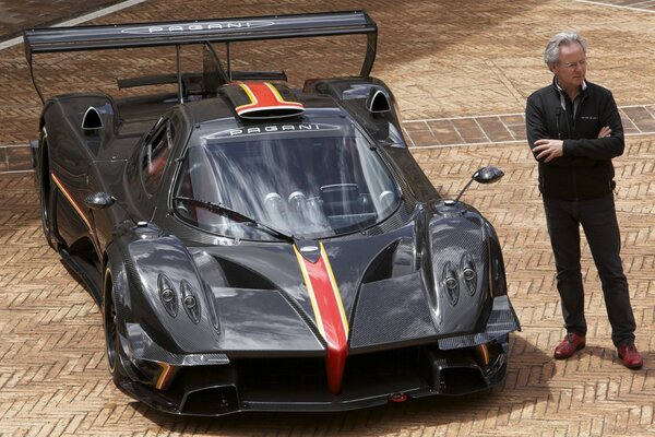 L uomo è in piedi accanto alla supercar. Pagani sembra molto impressionante