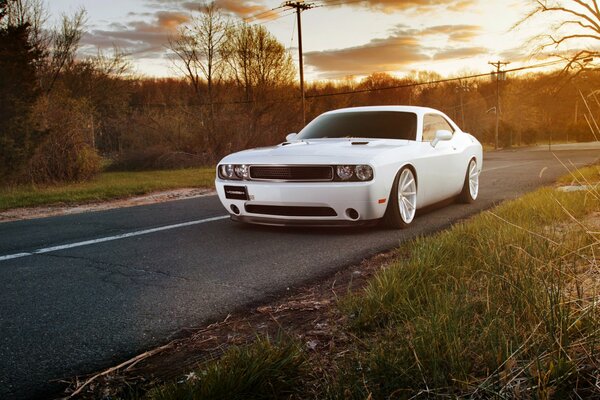 A white Dodge is standing on the curb
