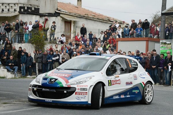 Dolce Peugeot bianco e blu circondato da spettatori