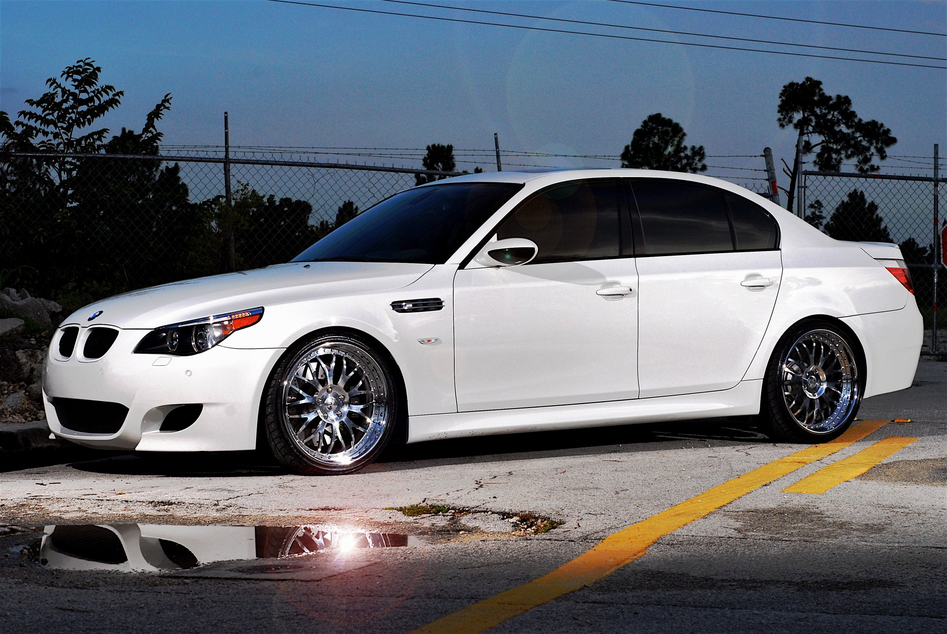 bmw m5 e60 white bmw sedan tinted side view road marking puddle fence