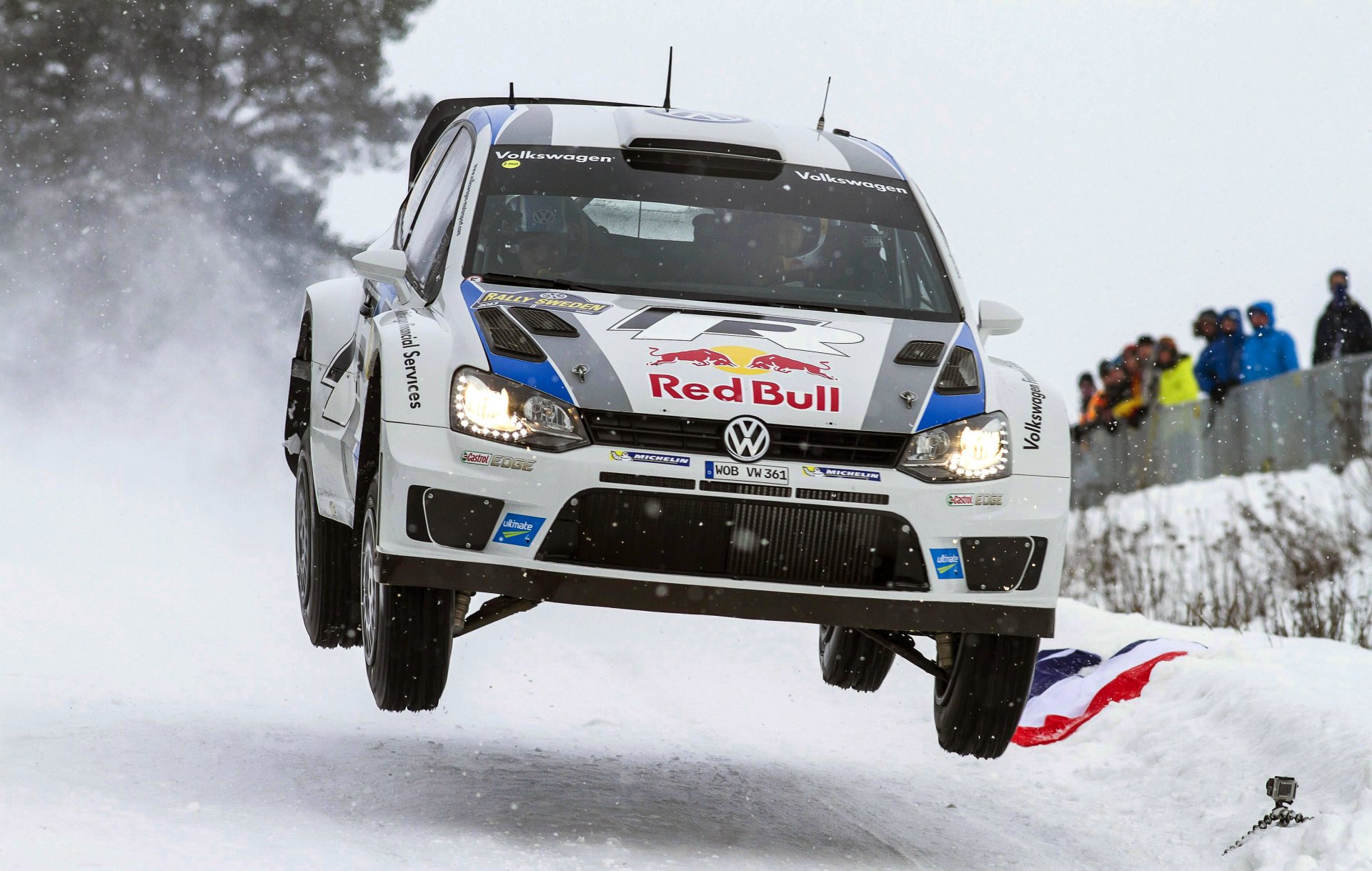 volkswagen polo wkr rallye sport auto rallye schnee winter weiß roter stier sebastian ogier julien ingrassia in der luft fliegt menschen lichter