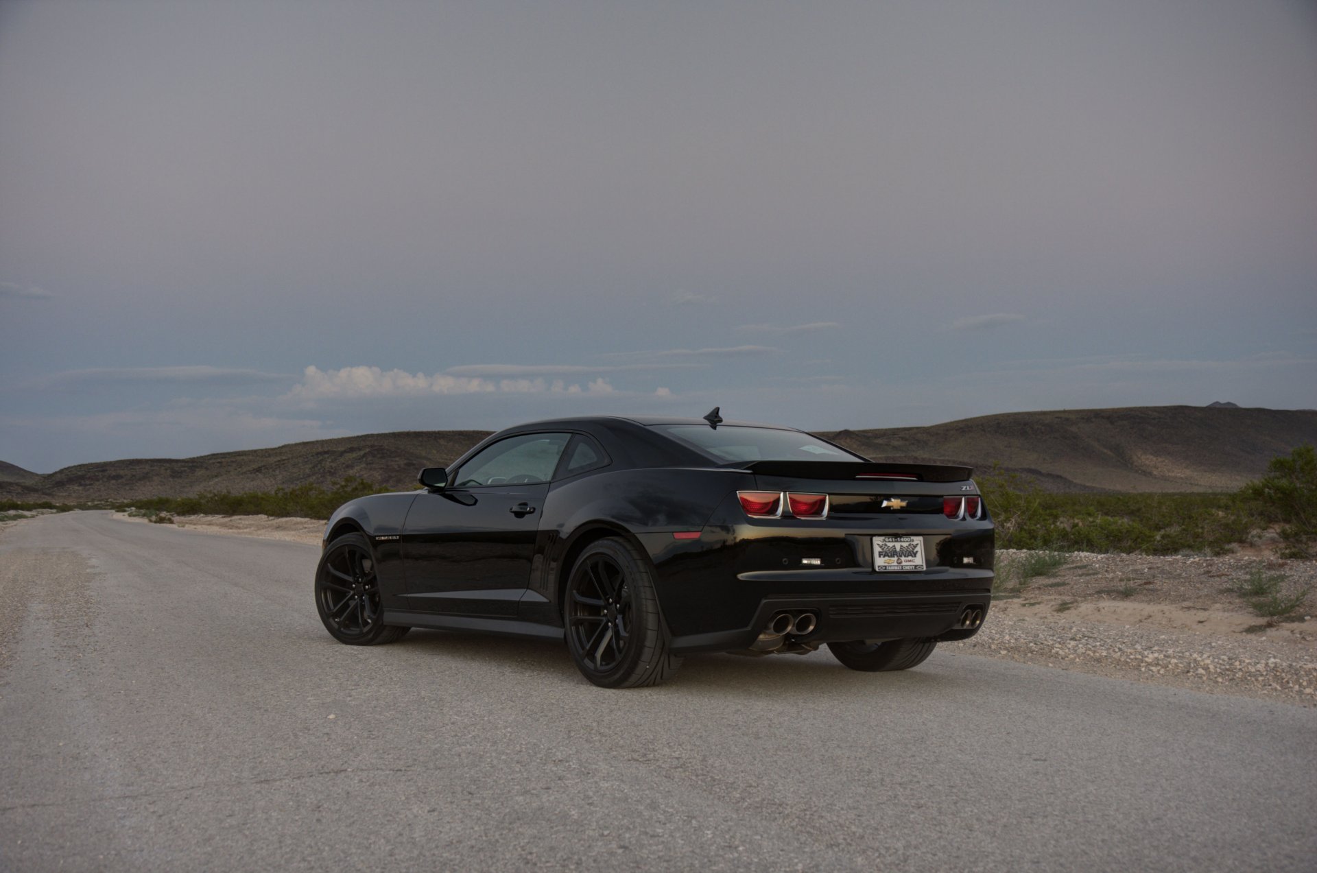 chevrolet camaro zl1 negro ruedas chevrolet camaro zl1 vista posterior llantas negras carretera hierba pendiente línea del horizonte