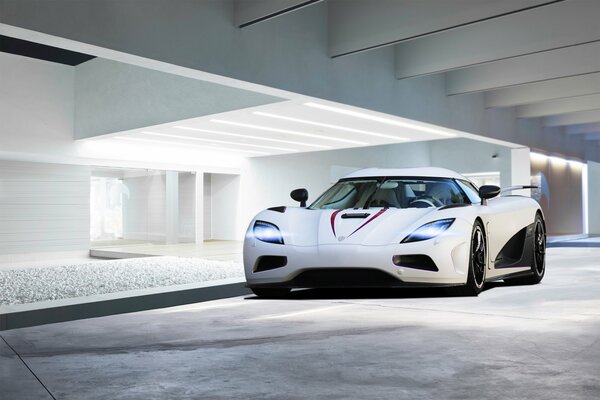White koenigsegg agera r on the background of a white room with highlights