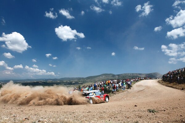 Los espectadores en el Rally miran a Citroën en una curva