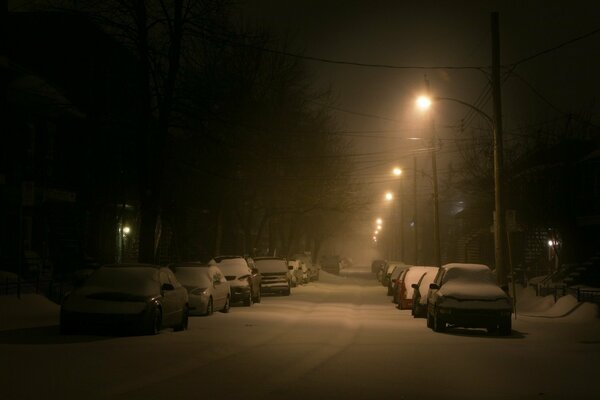 Noche de nieve entre la carretera y los coches