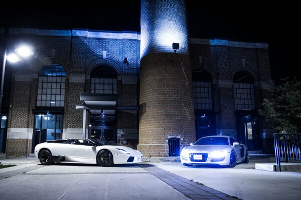 Voitures Lambotghini en blanc dans la rue dans un éclairage bleu