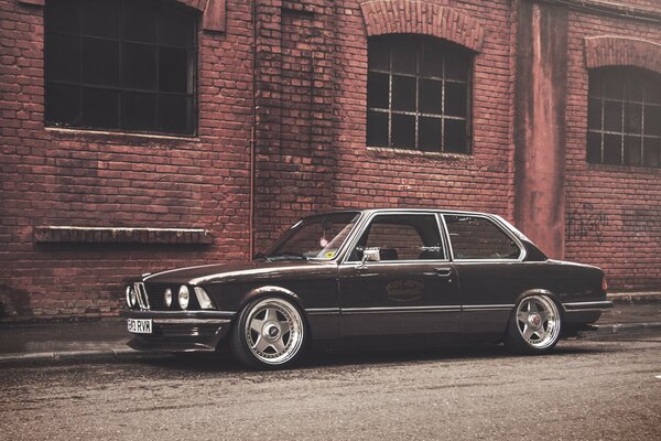 Noir bmw E21 coupé sur fond de vieux bâtiment en brique