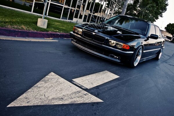 Voiture noire BMW 740 E38 sur route