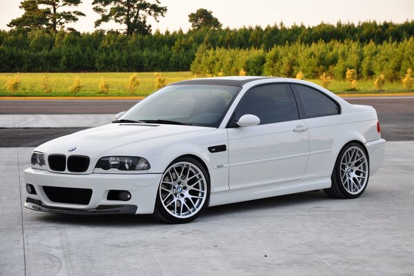 Coche blanco de BMW en la cubierta concreta