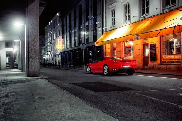 Ferrari rouge dans les vitrines de nuit
