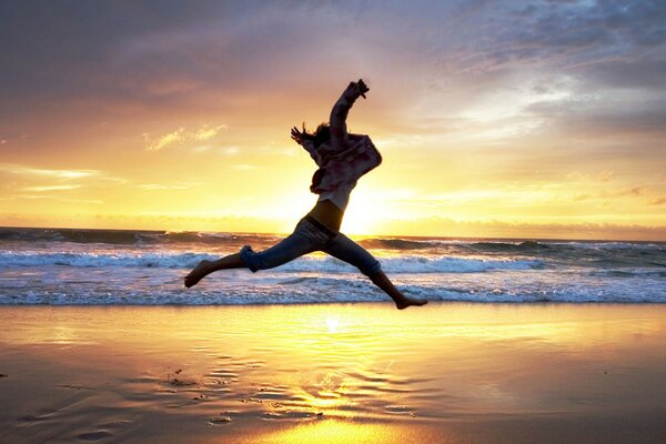 Foto von einem Sprung am Strand bei Sonnenuntergang