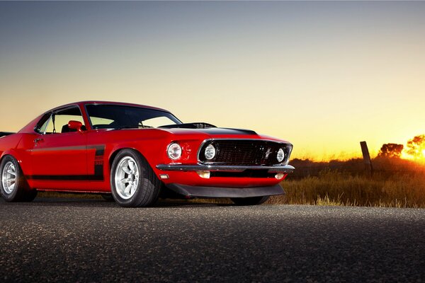 Une vraie voiture Mustang masculine au coucher du soleil