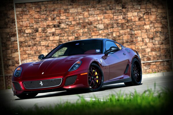 Voiture rouge Ferrari 599 TRP près de l herbe