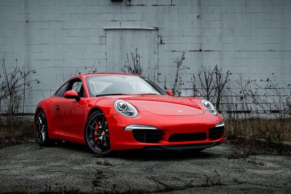 A red Porsche car on a wall background