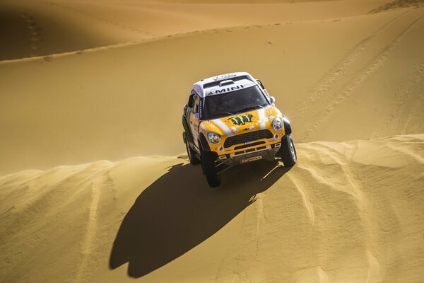 Mini cooper jaune sur une dune de sable