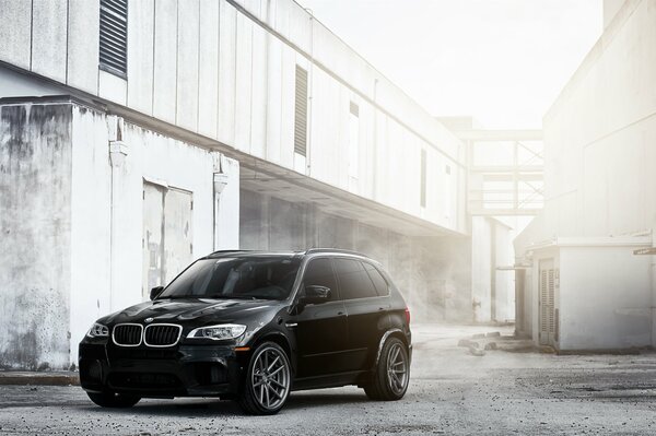 BMW noir dans la brume sur le fond du bâtiment