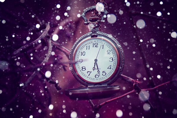 Pocket watch on a chain on a lilac background