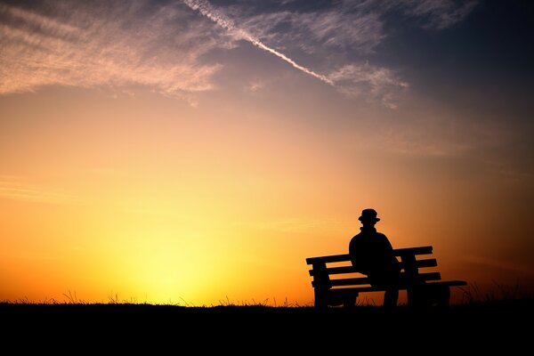 Beau coucher de soleil avec un homme sur un banc