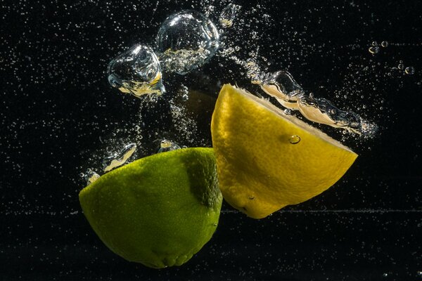 Limone e lime cadono in acqua