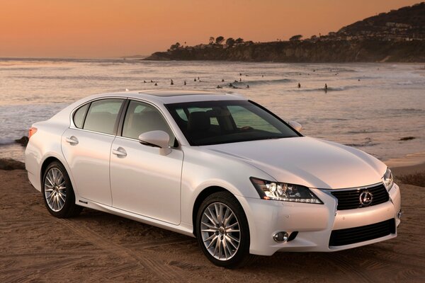 Lexus GS450h na plaży o zachodzie słońca