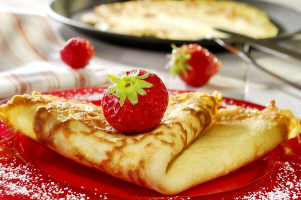 Crêpe aux fraises sur une assiette rouge