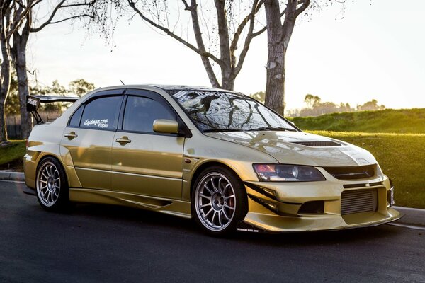 Goldener mitsubishi Lancer bei Sonnenuntergang