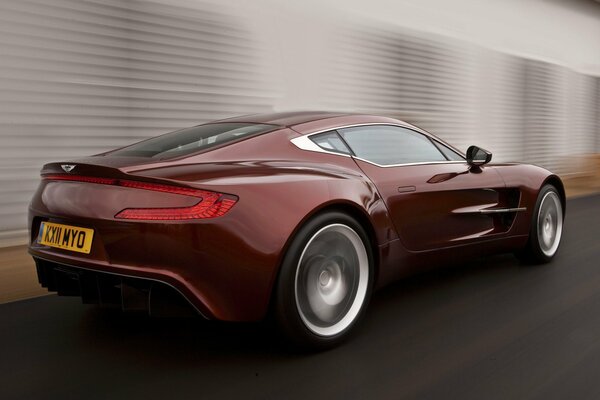 Car wallpaper with a red aston Martin car in motion