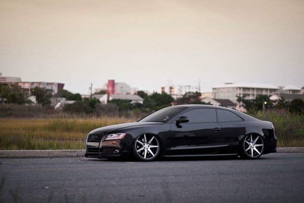 Black understated Audi car on the background of the city