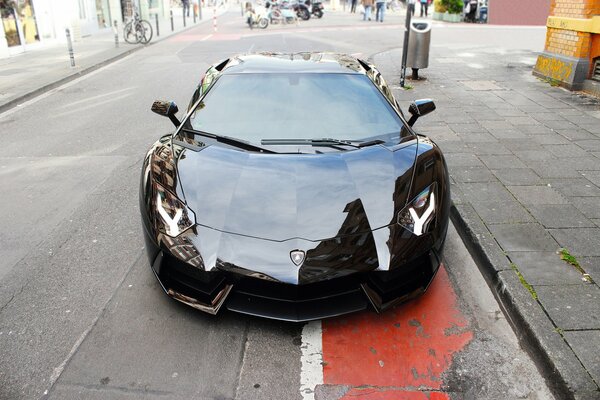 Schwarzes Lamborghini-Auto auf dem Hintergrund der Straße