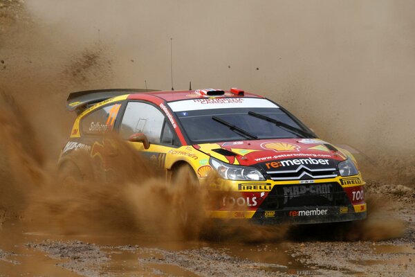 El auto participa en el Rally y crea salpicaduras en la curva