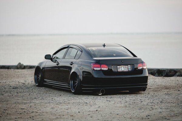 La voiture de LexUM est noire en solitaire sur la route de sable
