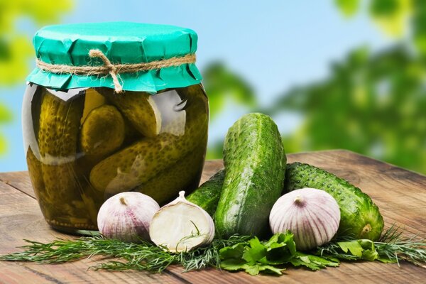 A jar of pickled cucumbers and fresh herbs