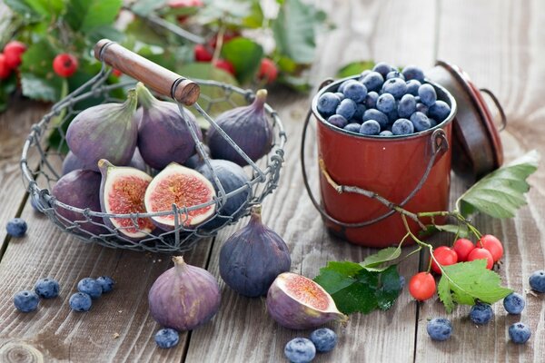 A basket of figs and a bucket of blueberries