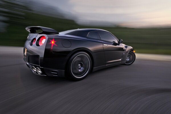 Nissan noir à l entrée du virage avec fond huilé