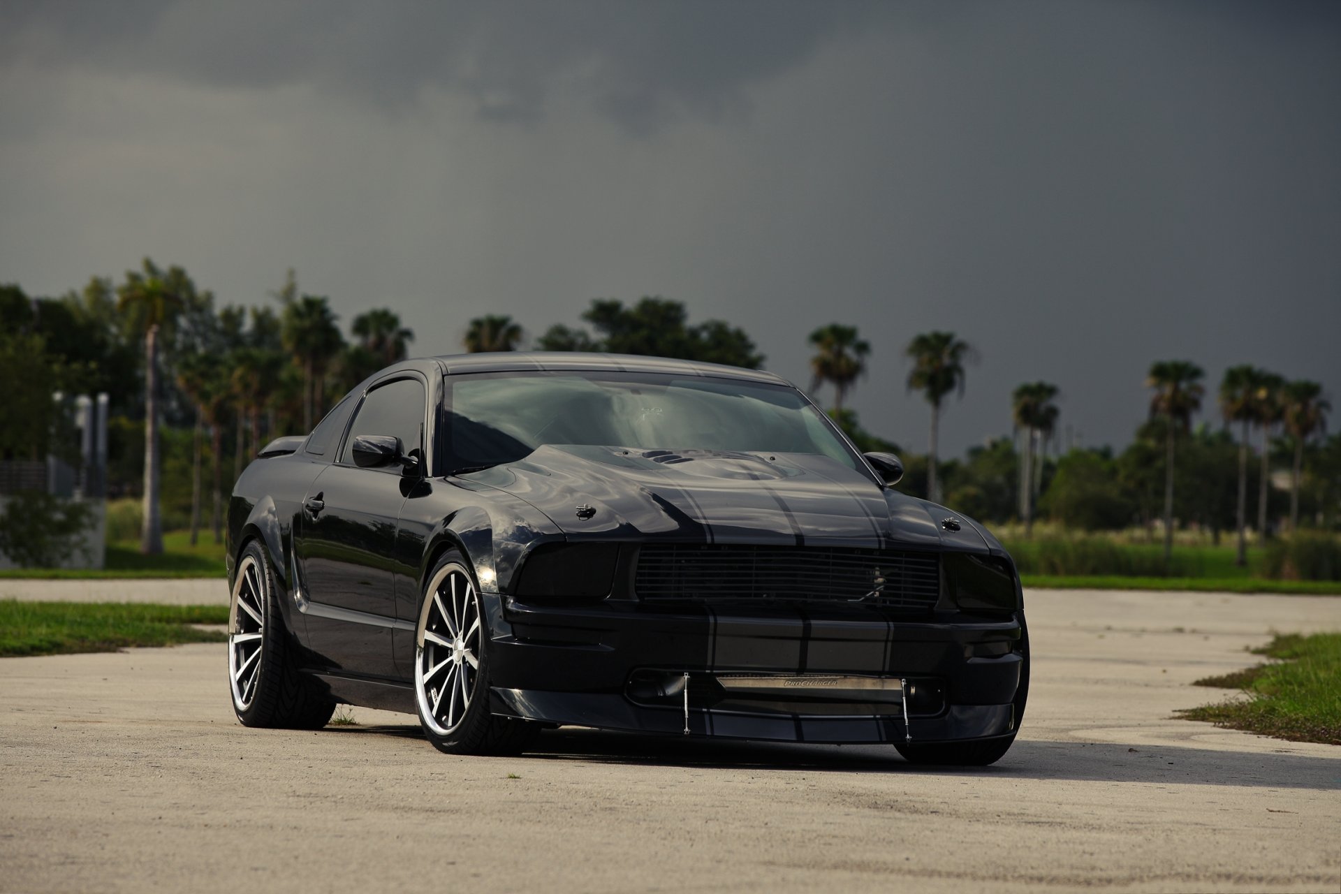 ford mustang noir teinté ciel nuages jantes vue de face