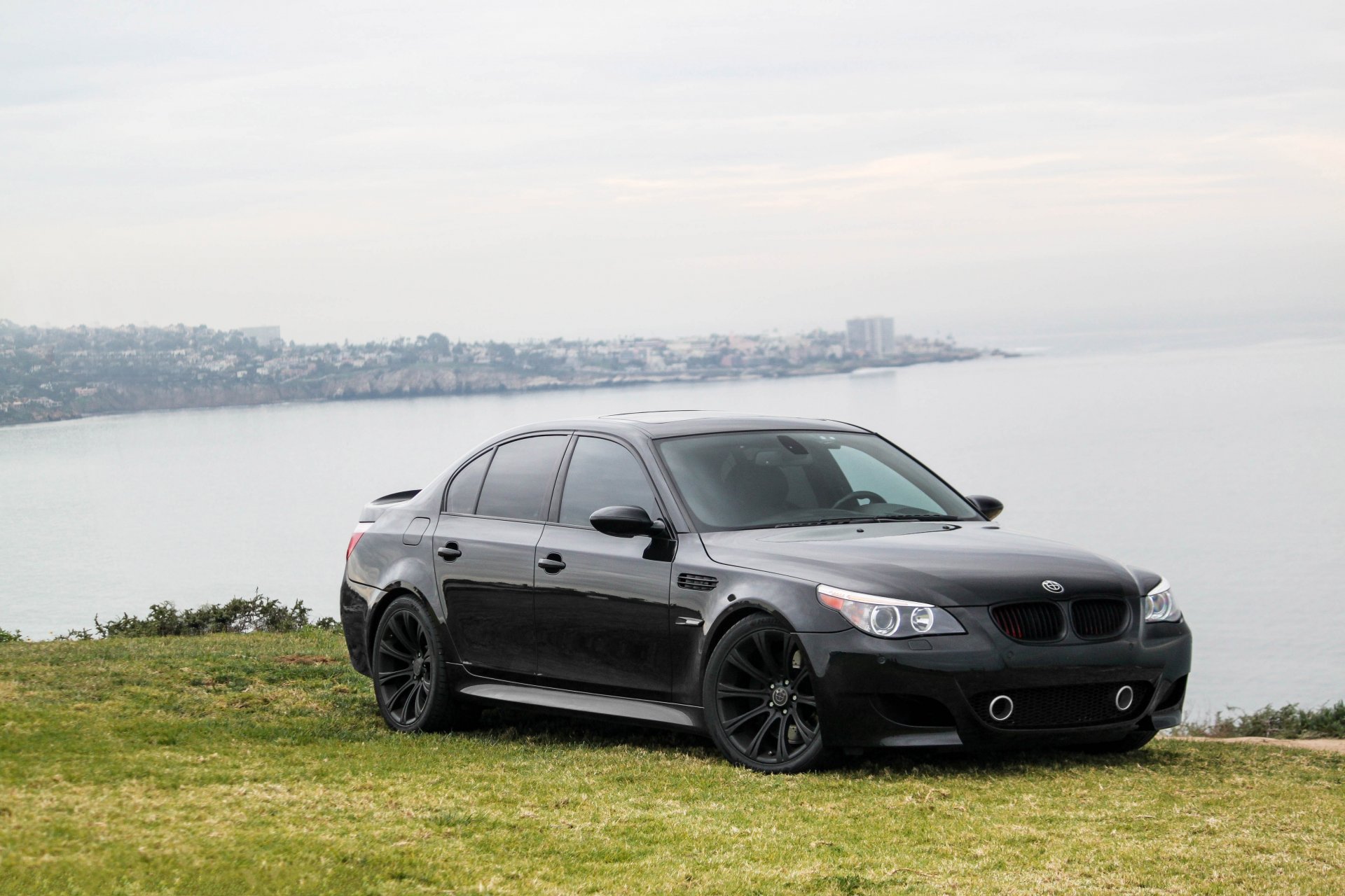 bmw m5 e60 negro bmw sedán deportivo césped mar cielo nubes